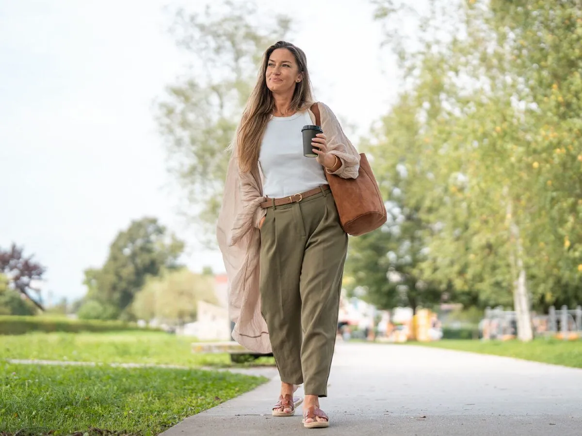 woman walking outside with a coffee in her hand