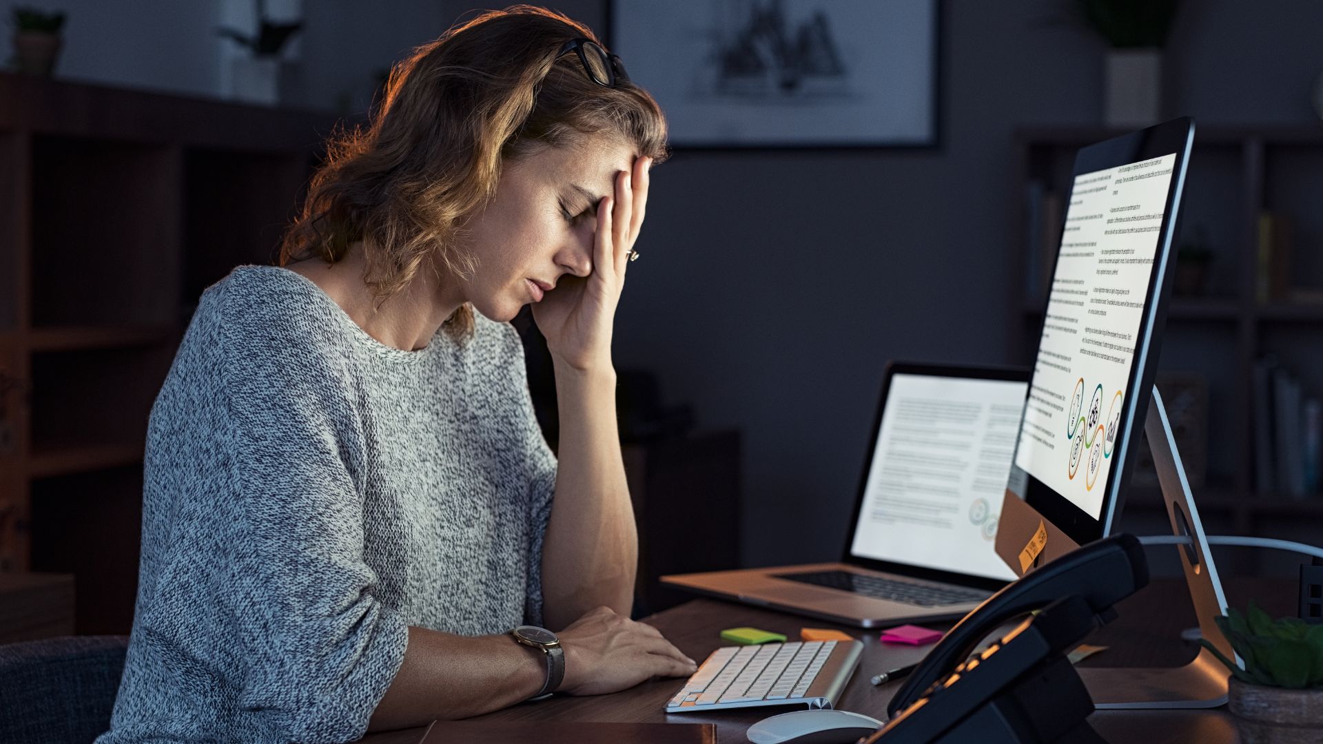 Employee stressed out looking at three screens
