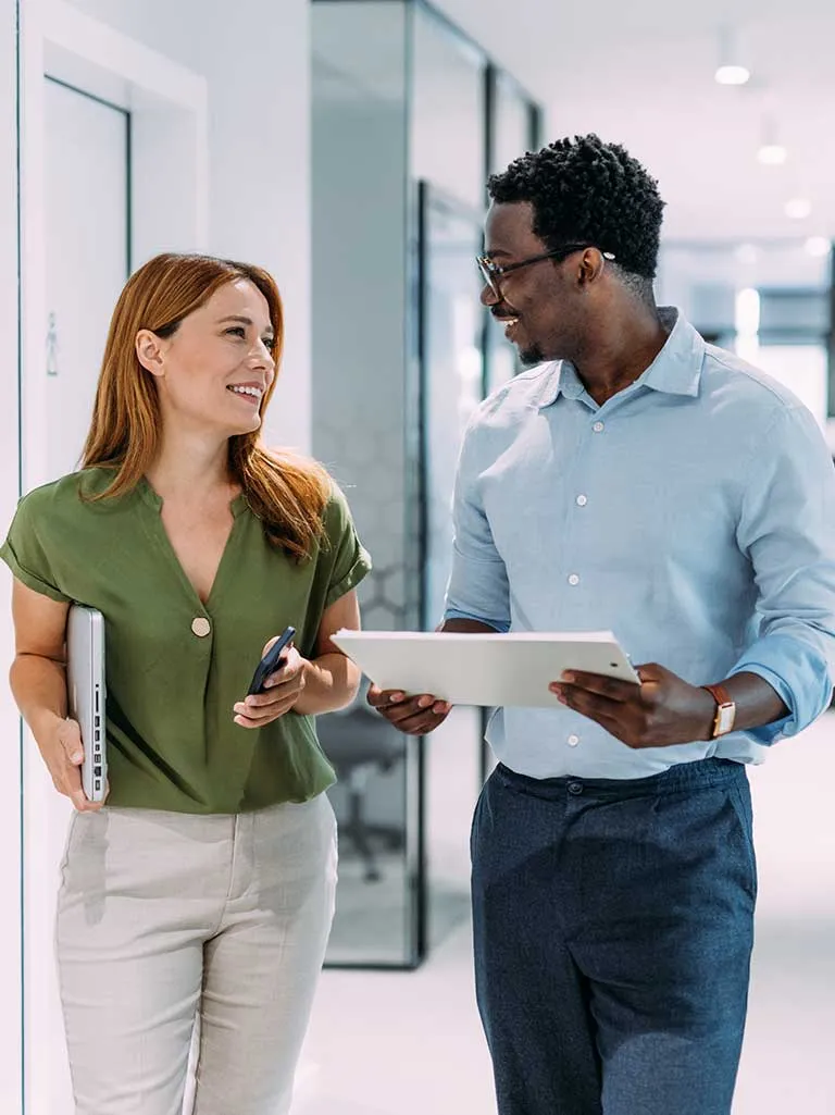 female and male coworker walking and talking at work