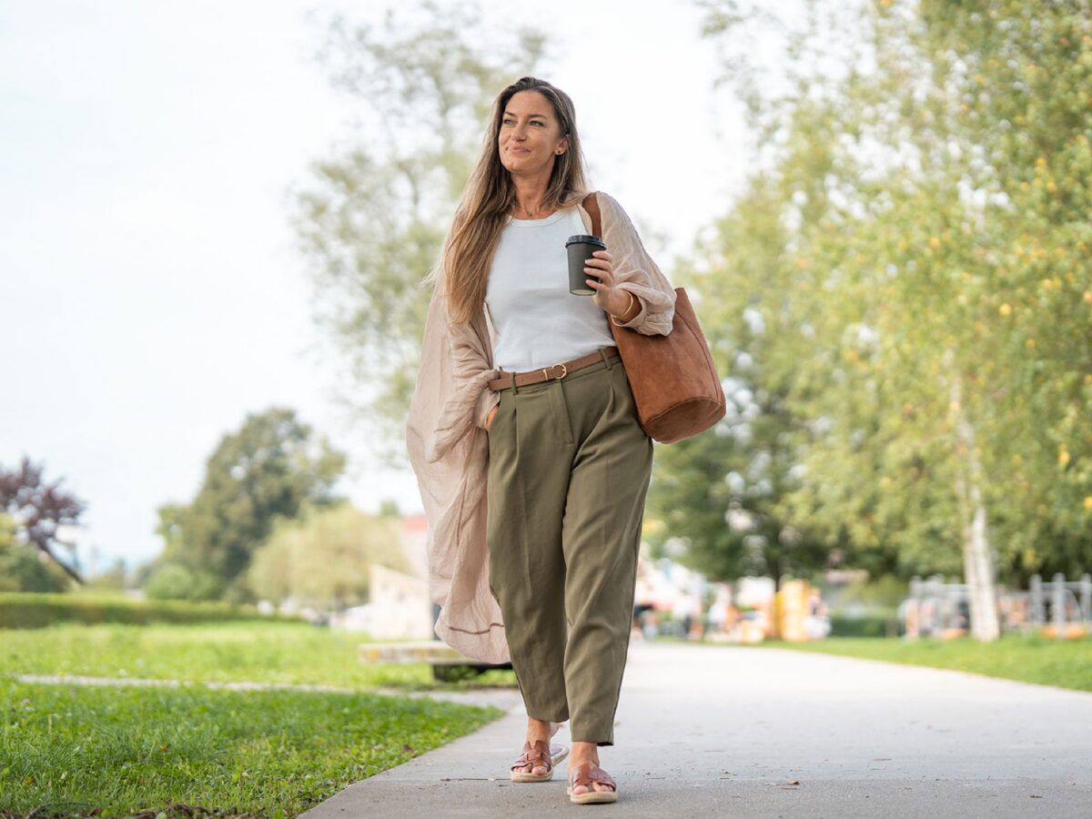 woman walking outside with a coffee in her hand