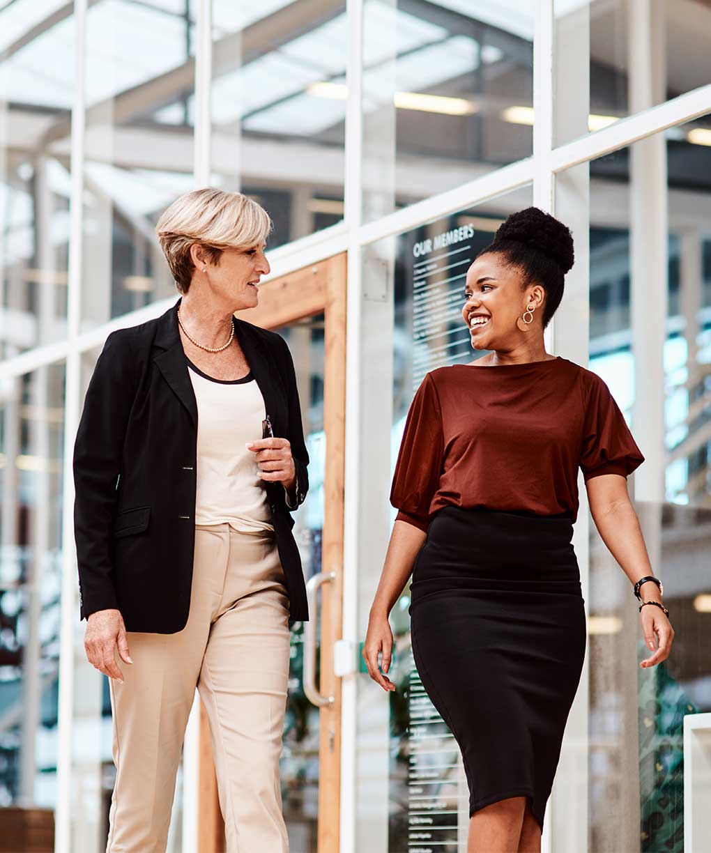 two female coworkers talking and walking in their workplace