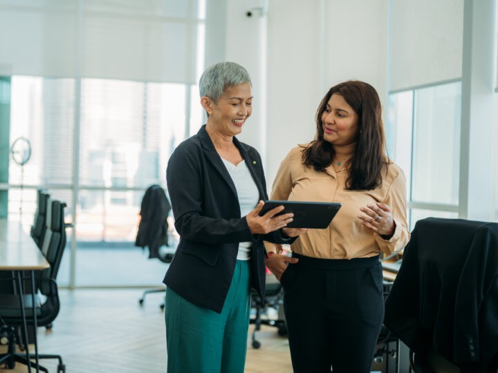 two middle-aged women collaborating in an office setting