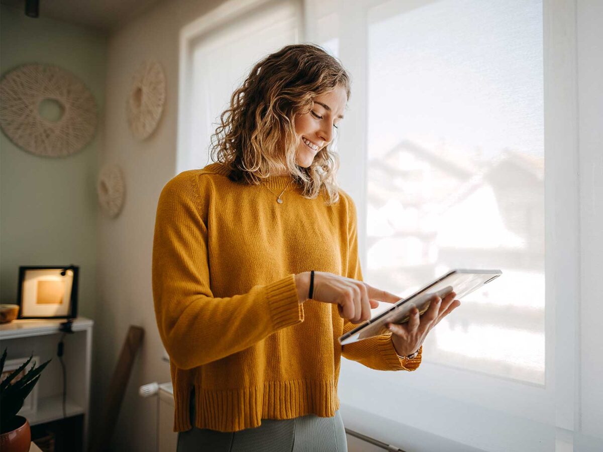 Woman smiling and responding to fun employee survey questions on her tablet