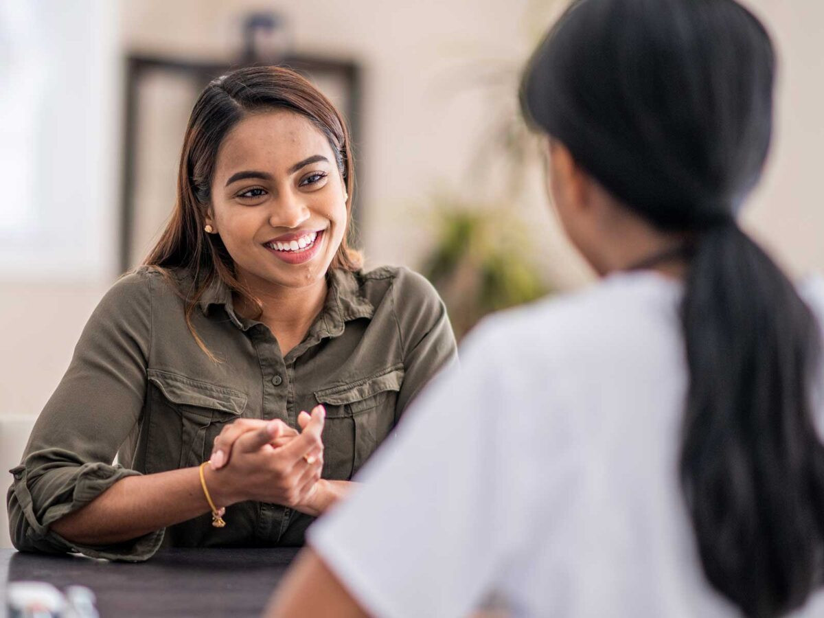two female employees discussing onboarding at work