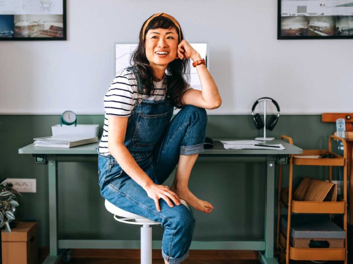 Woman sitting on a stool at her work station smiling