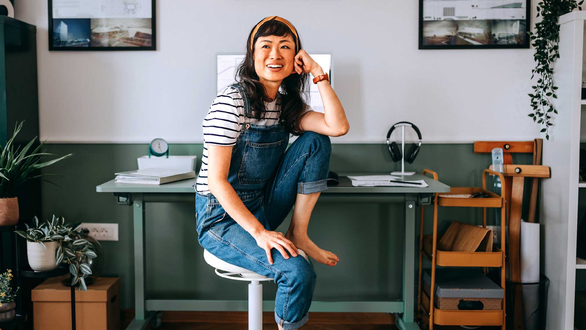 Woman sitting on a stool at her work station smiling