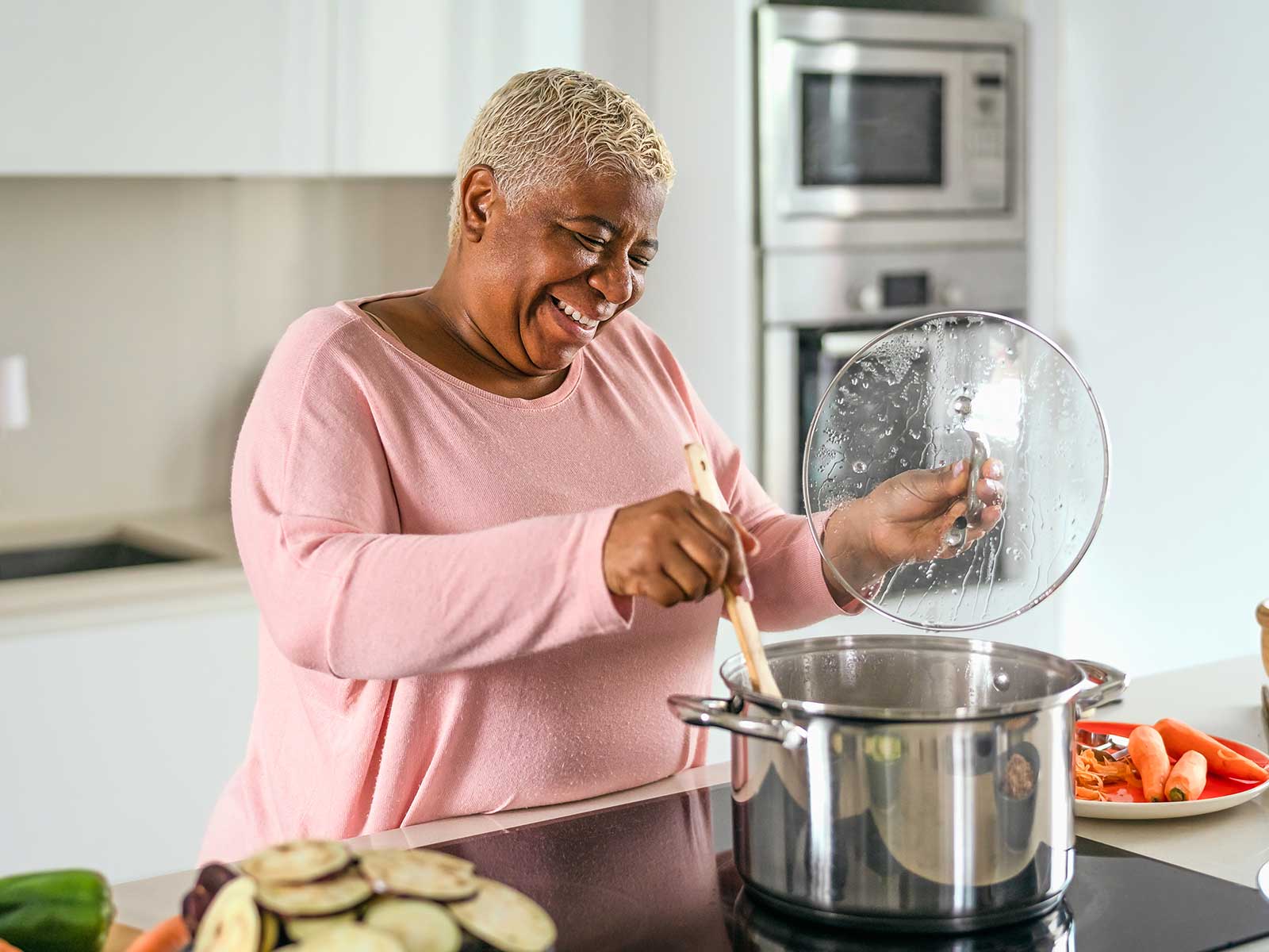 woman cooking at the stove smiling