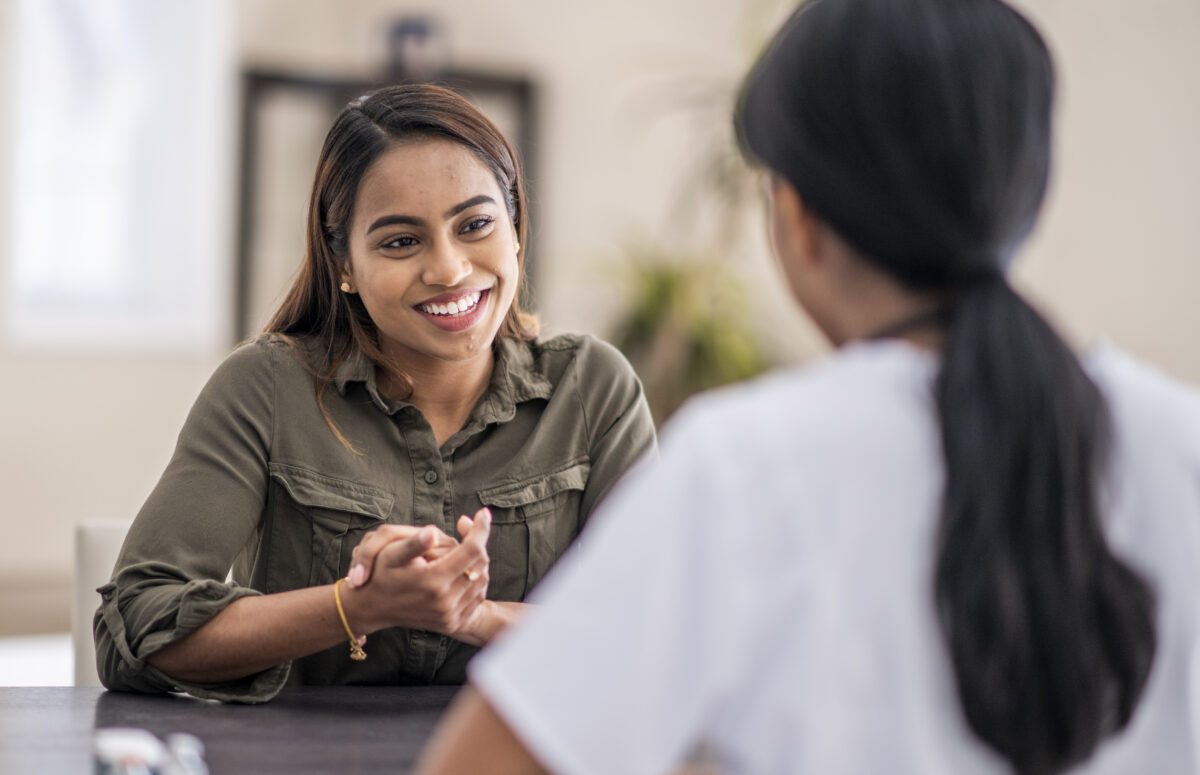 two women sitting at a table talking