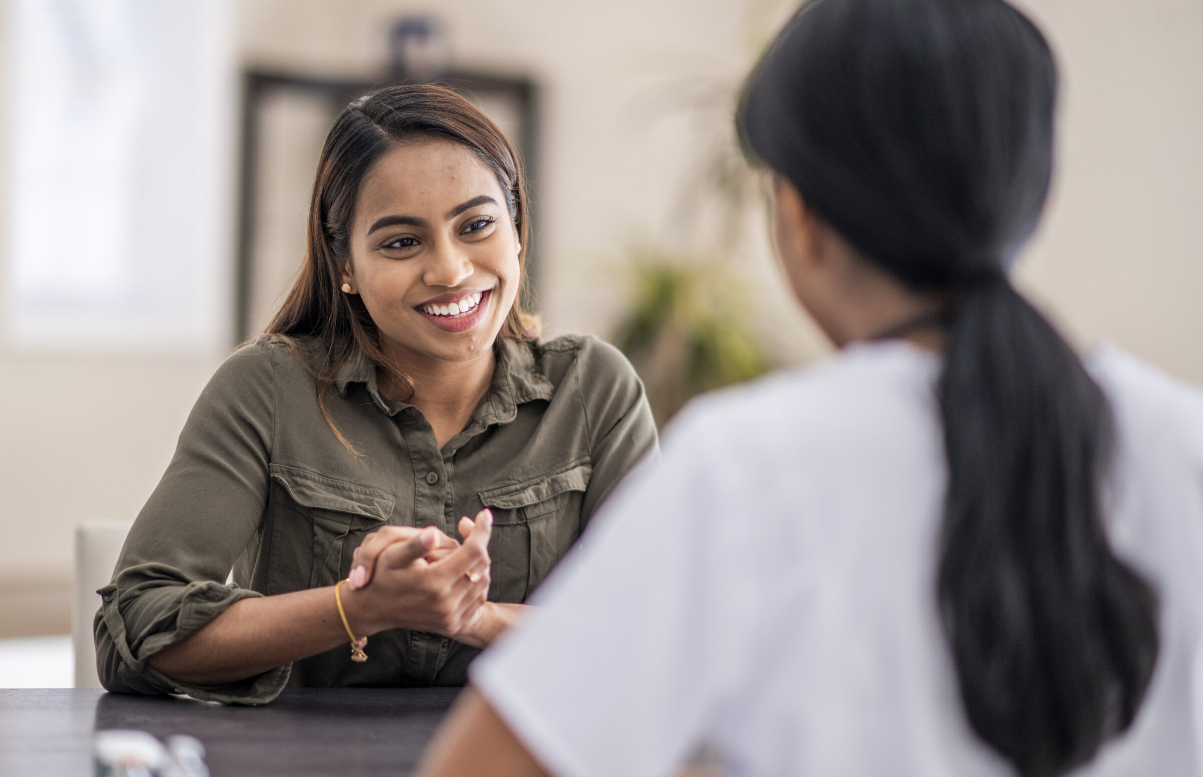 two women sitting at a table talking
