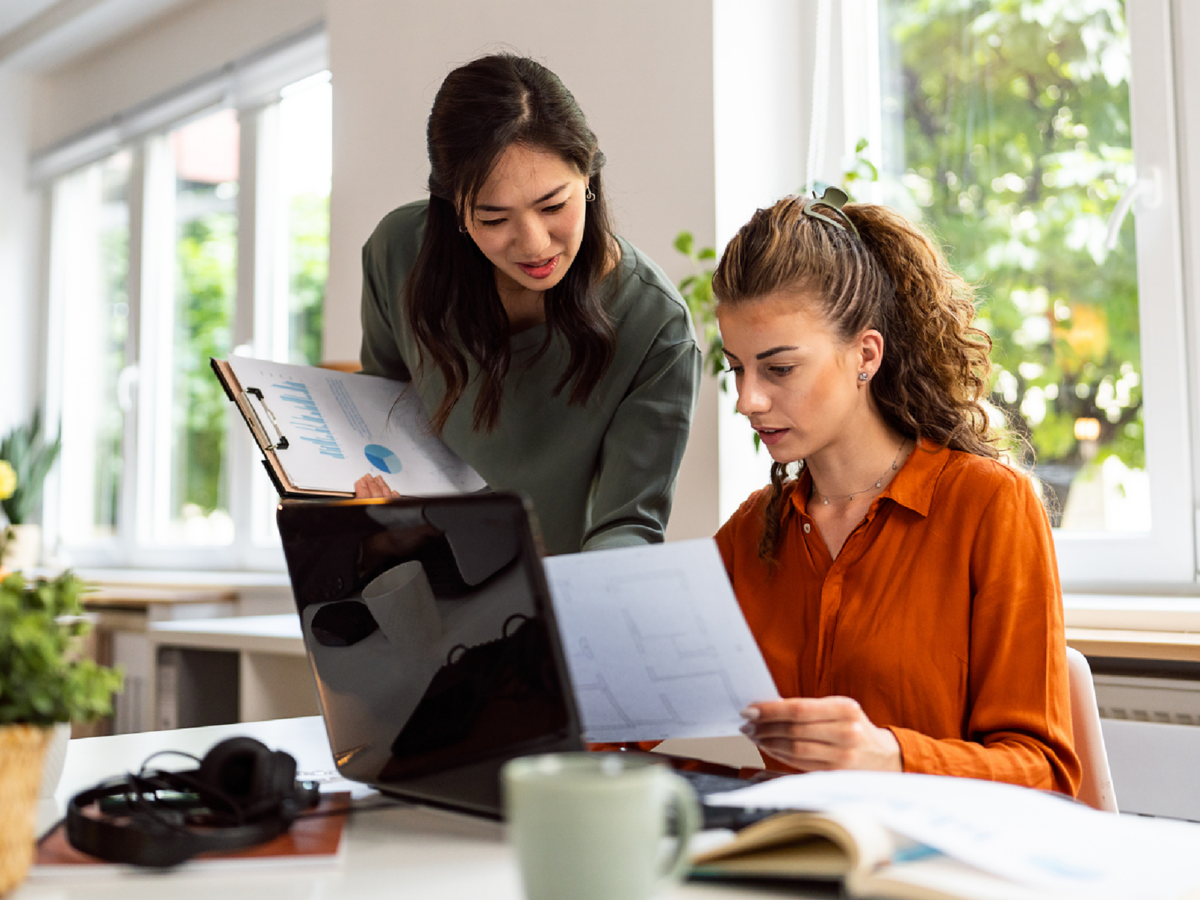 Employees reviewing work together at their desk