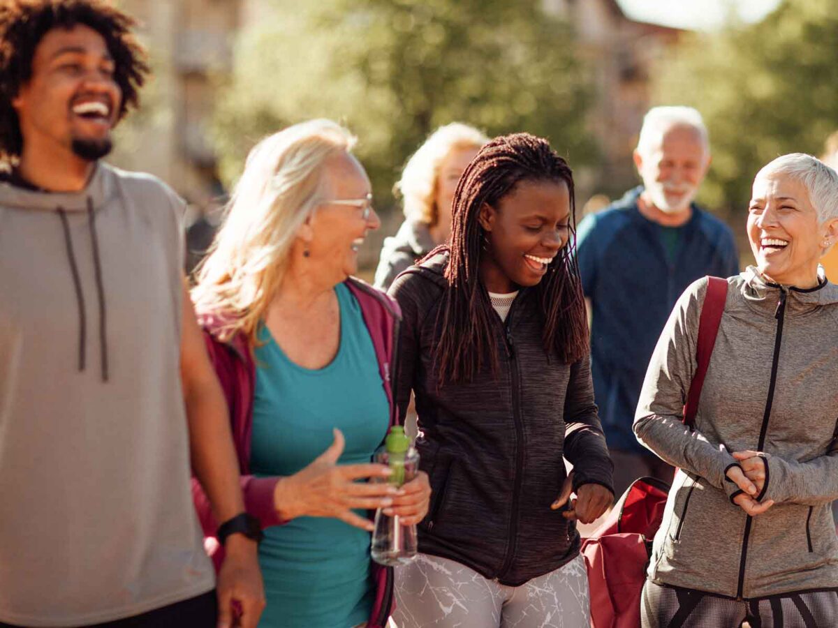 employees smiling and laughing after completing an exercise class outside during a lunch break