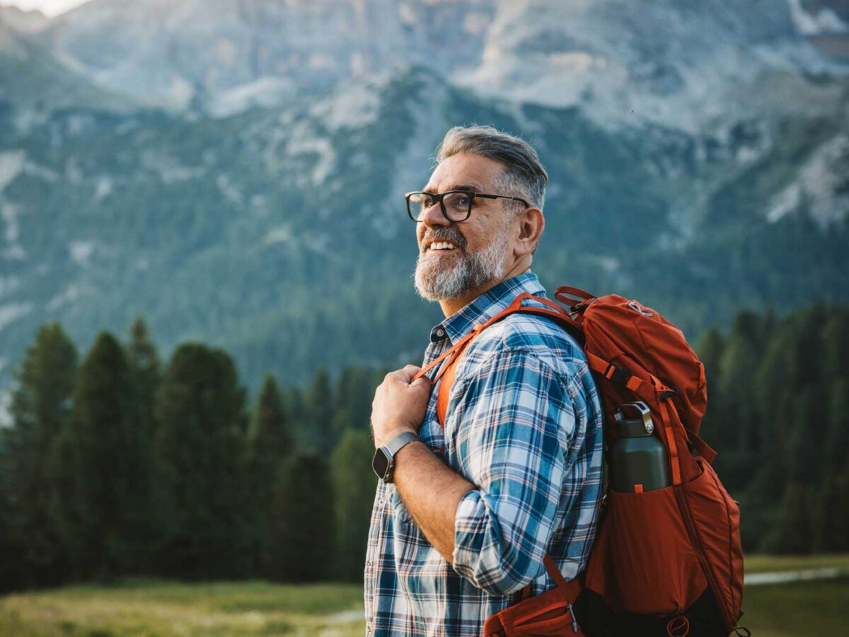 older man smiling while hiking