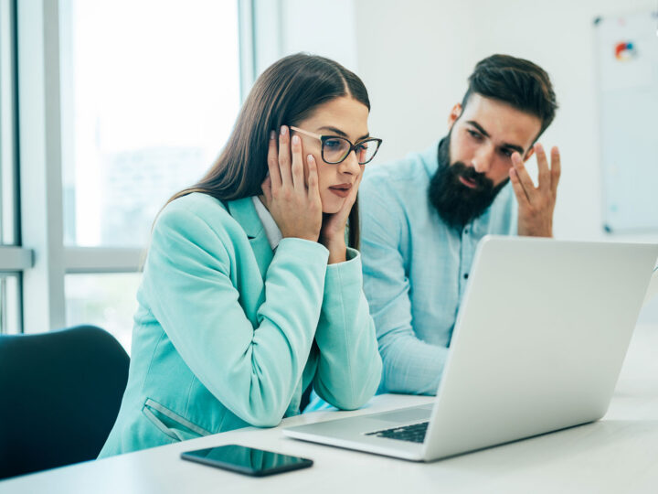 female and male employee looking at a computer, analyzing employee turnover costs