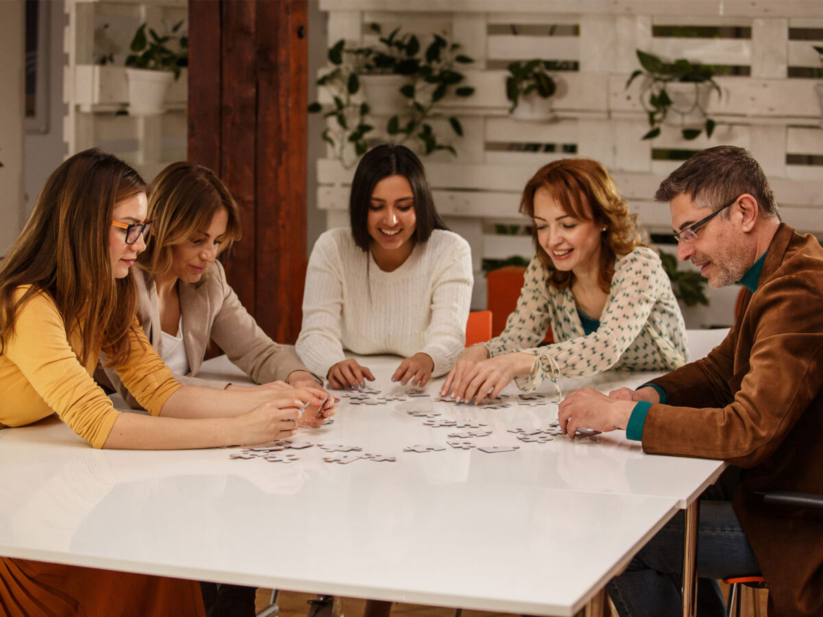 group of coworkers doing bonding over a puzzle as a non-happy-hour team bonding activity