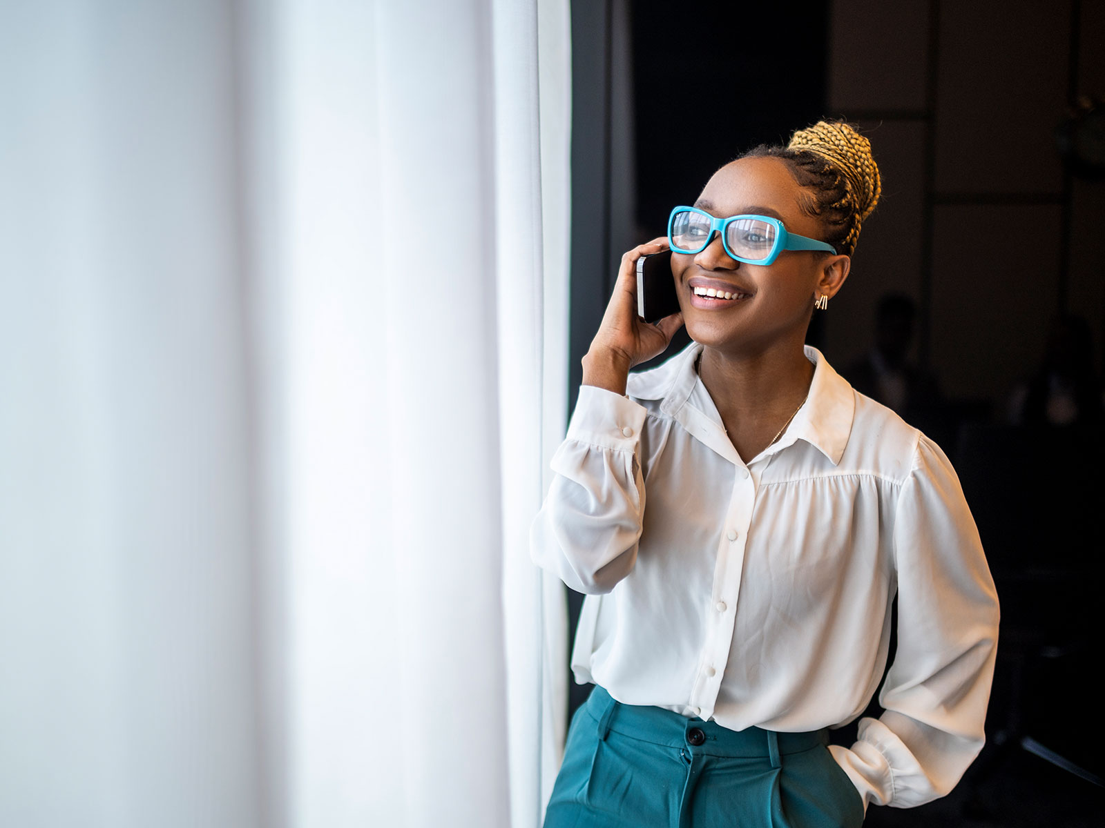 African American woman smiling while talking on the phone in her office