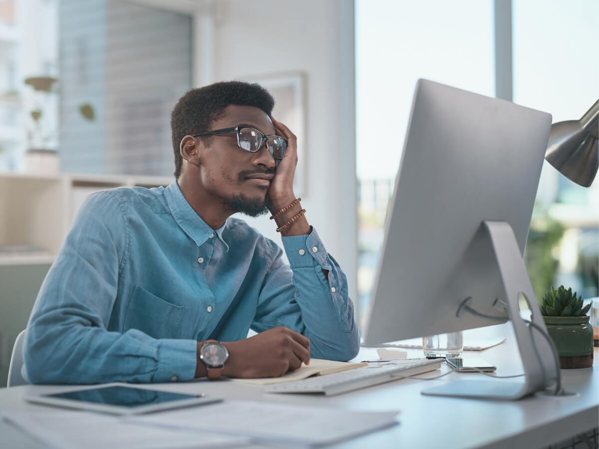 burned out male employee looking at his computer