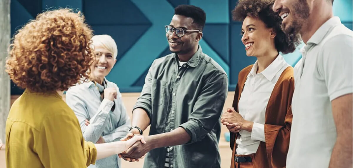 group of employees smiling and shaking hands