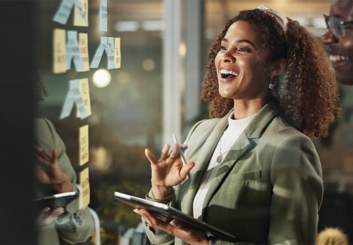 employees smiling and looking at post it notes
