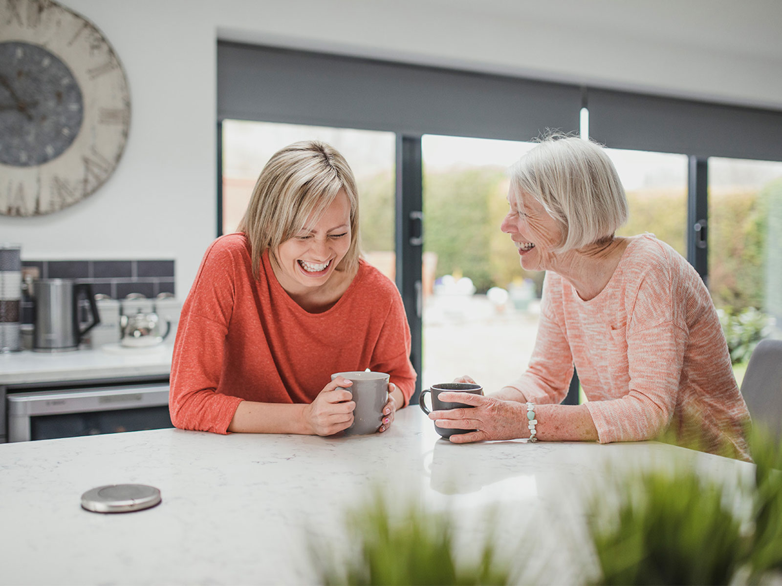 Two HR Leaders smiling in the office while having coffee in the kitchen